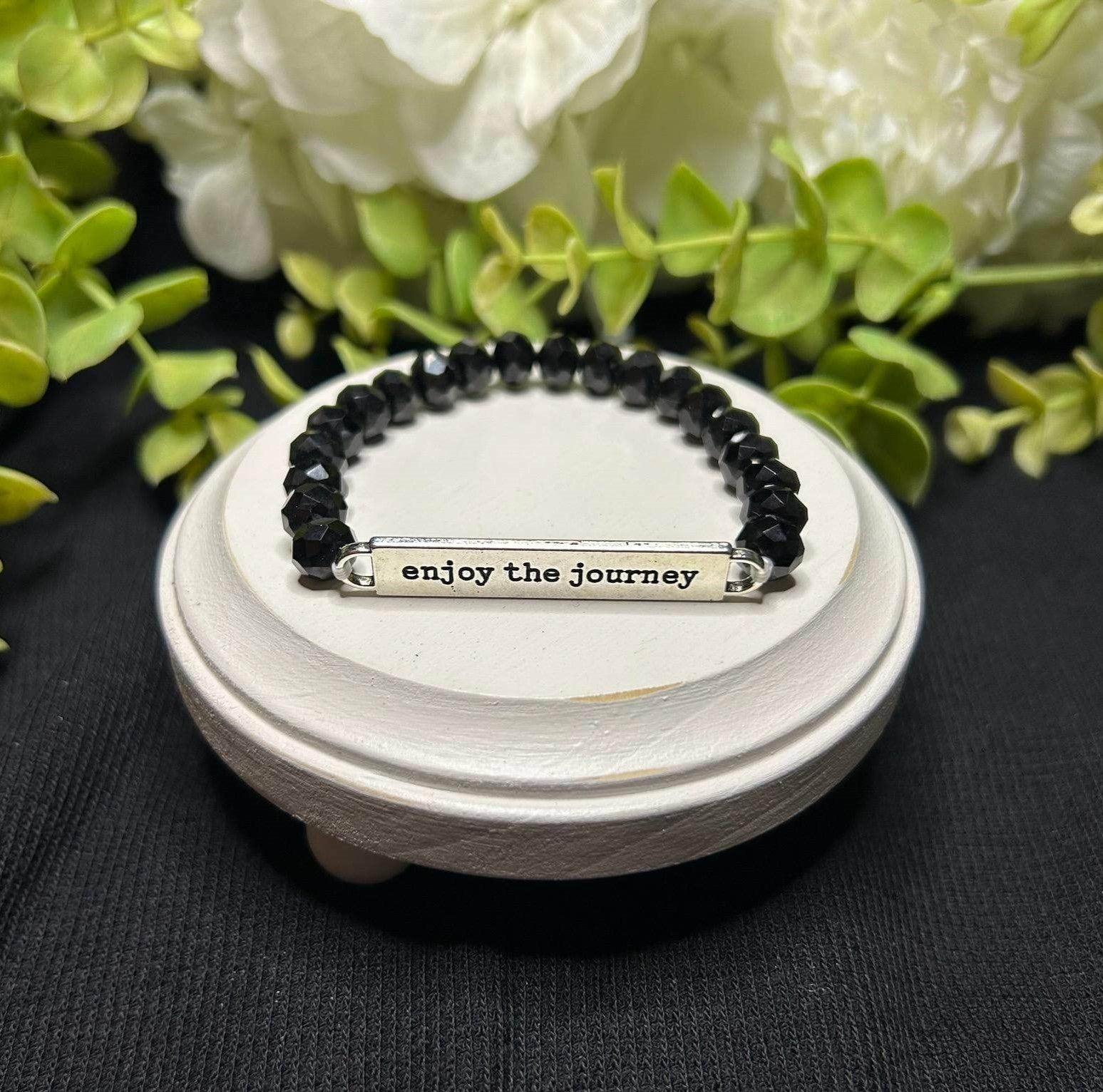 black beaded bracelet says "enjoy the journey"